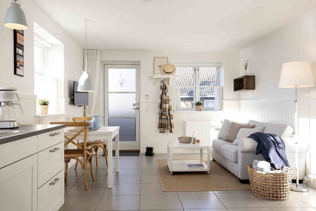 Un espace de vie compact comprenant un coin cuisine, un coin repas et un coin salon avec un canapé et une table basse.