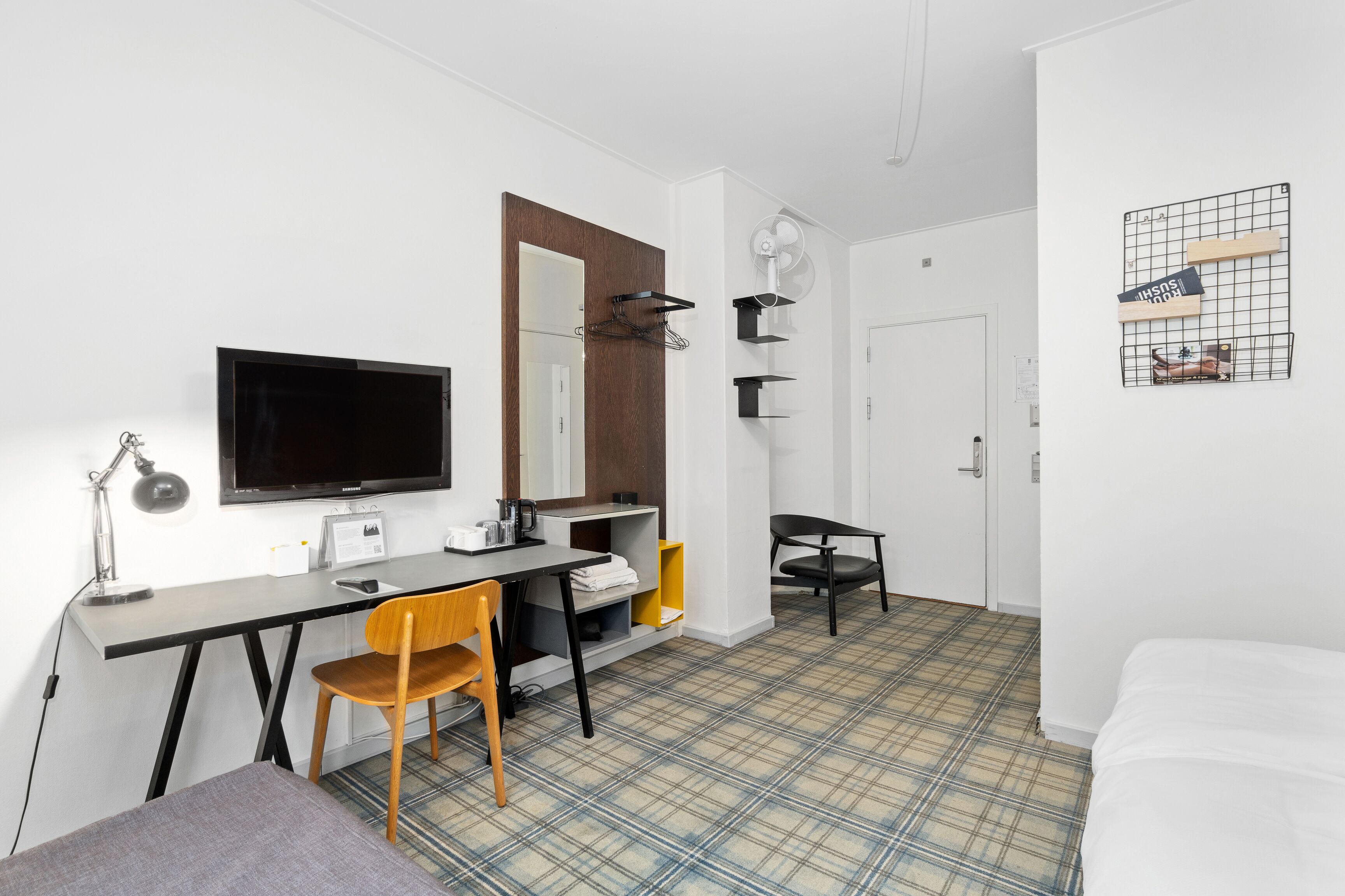 A modern room with a desk, chair, and a bed.