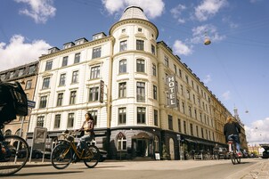A corner building with a "HOTEL" sign, a bicycle parked in front, and a "Cycleway Zone" sign.