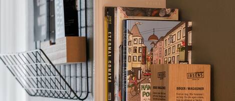 A bookshelf with books and a wooden box labeled 'BØGER / MAGASINER'.