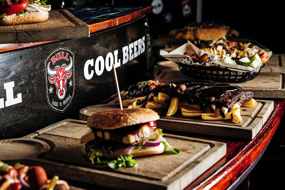 Zona de bar con un letrero que dice "BULL COOL BEERS" y el logo de un toro.