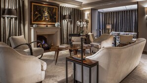 A spacious living room with a fireplace, comfortable seating, and a large painting on the wall. - Esprit Saint-Germain (Paris)