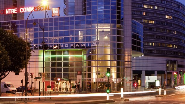 A hotel with a modern glass facade and signage for 'HOTEL' on both sides. - ibis Paris Porte De Montreuil (Paris)