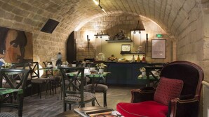 Un restaurante con paredes de piedra, mesas, sillas y una zona de bar.