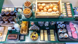 A breakfast buffet with various food items including eggs, pastries, and spreads. - Hotel Ariane Montparnasse by Patrick Hayat (Paris)