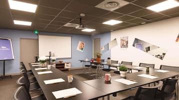A conference room with a long table, chairs, a projector screen, and a whiteboard.