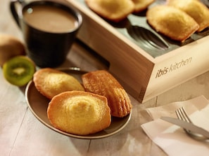 Un plato de pasteles, una taza de café y una caja de madera con la etiqueta 'ibis kitchen'.