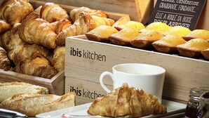 A variety of baked goods including croissants and muffins displayed in wooden boxes with a sign reading "Doree, Généréeuse, Graquante, Fondante". - ibis Lyon Gerland Rue Merieux (Lyon)