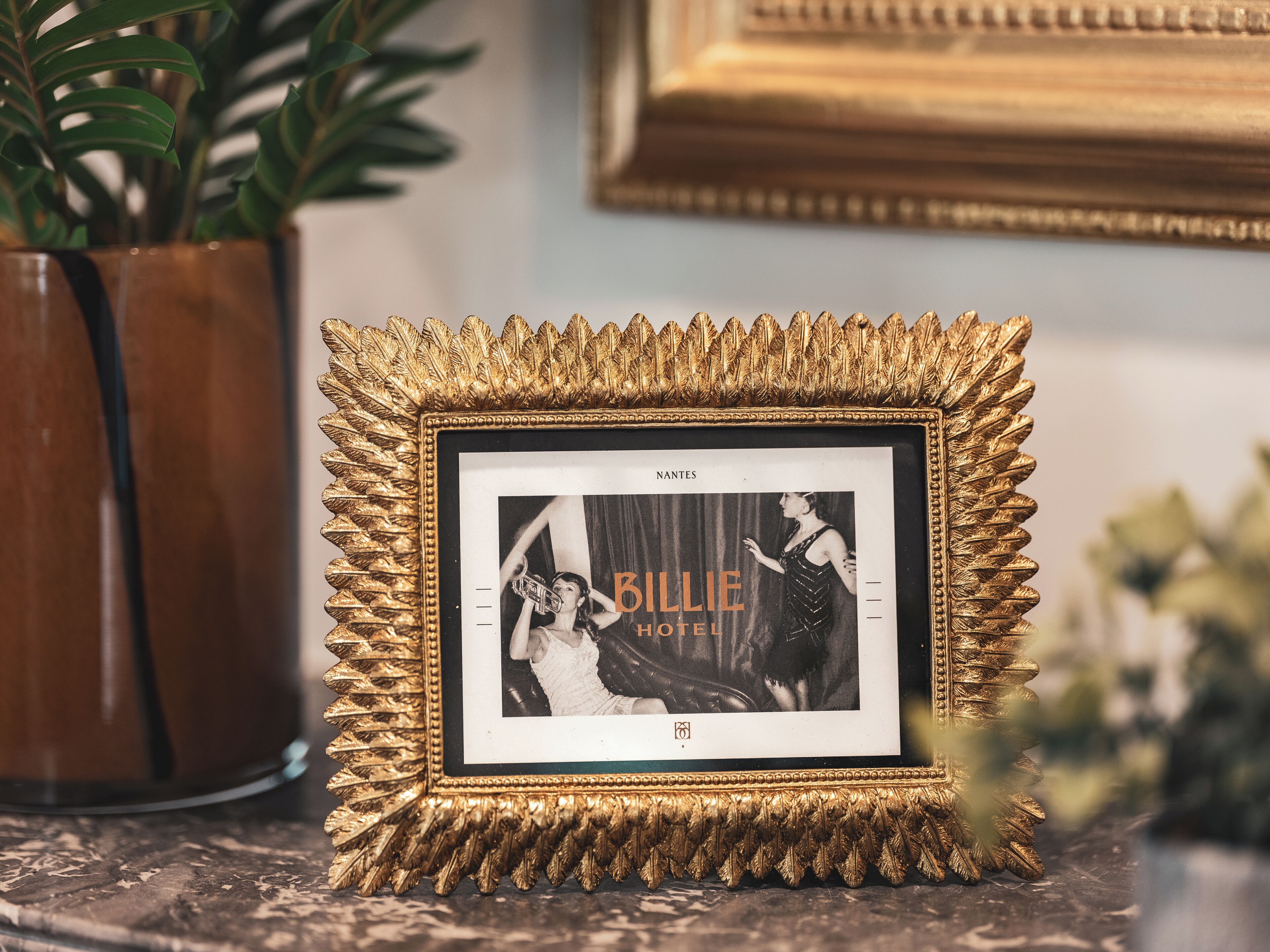 Une photographie encadrée représentant une femme en robe, avec les inscriptions « BILLIE HOTEL » et « NANTES ».