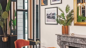 Un intérieur moderne agrémenté d’une cheminée, de tableaux encadrés et d’un fauteuil en velours rouge.