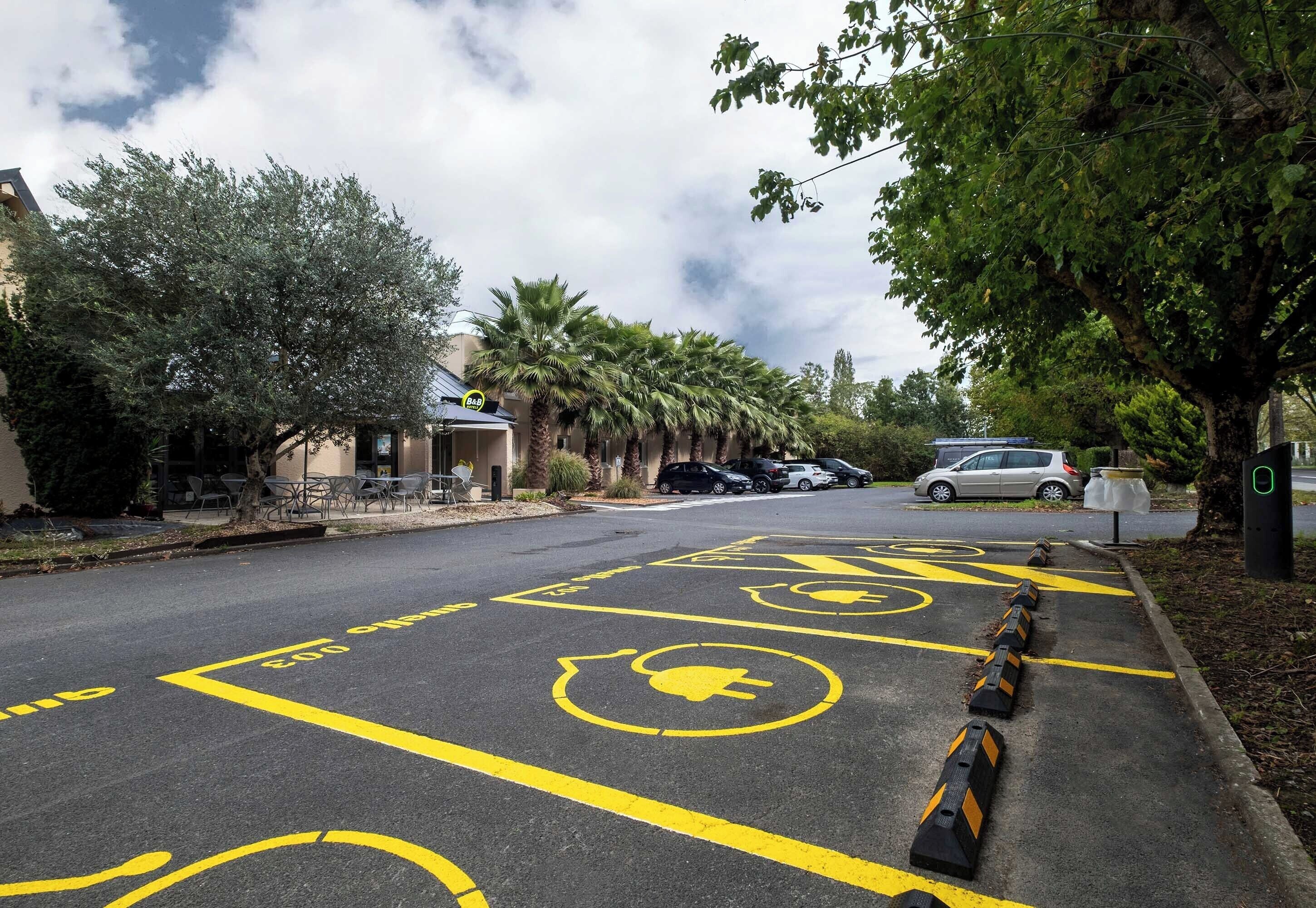 A parking lot with designated spaces for electric vehicles and disabled parking.