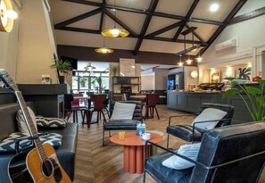 Ein moderner Lounge-Bereich mit Ledersofas, einem Couchtisch und einer Gitarre.