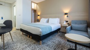 A hotel room with a bed, a desk, a chair, and a small table. - Sure Hotel by Best Western Bordeaux Lac (Bordeaux)