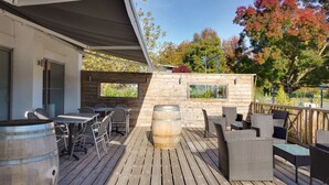 A wooden deck with outdoor seating, a large barrel, and a small building with windows. - Sure Hotel by Best Western Bordeaux Lac (Bordeaux)