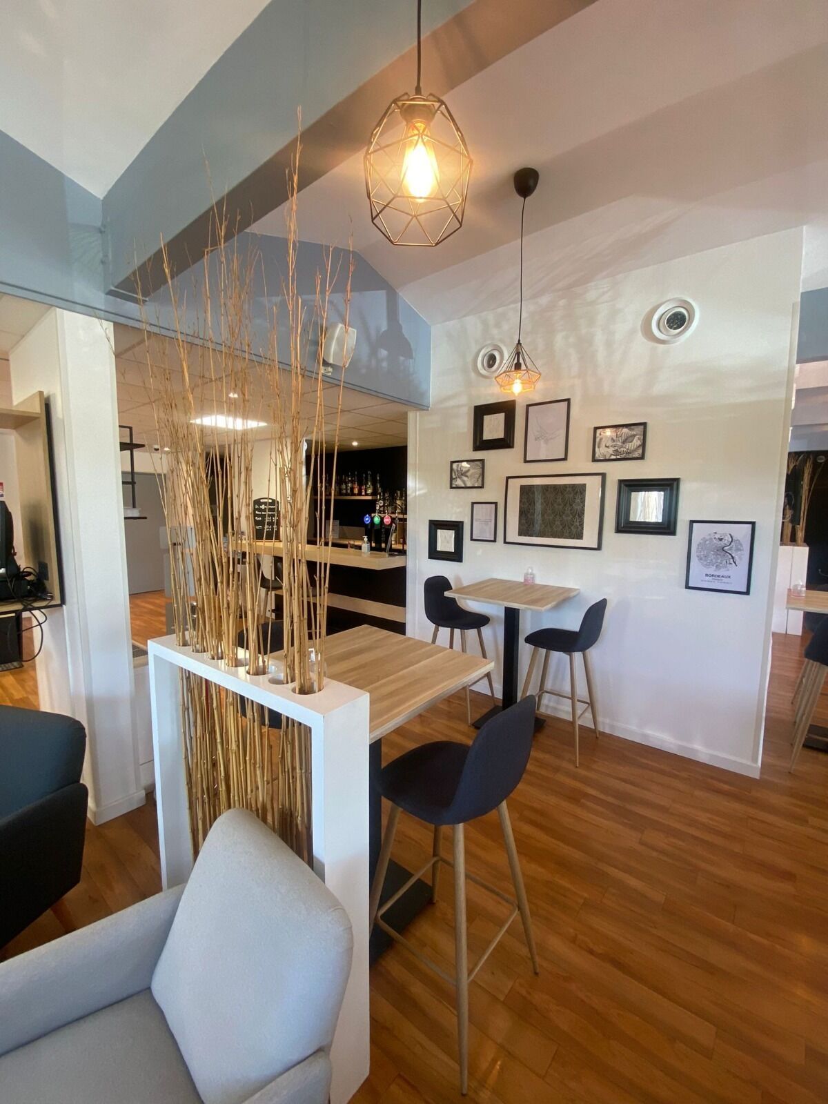Un interior moderno con una zona de comedor de madera, barra y asientos.