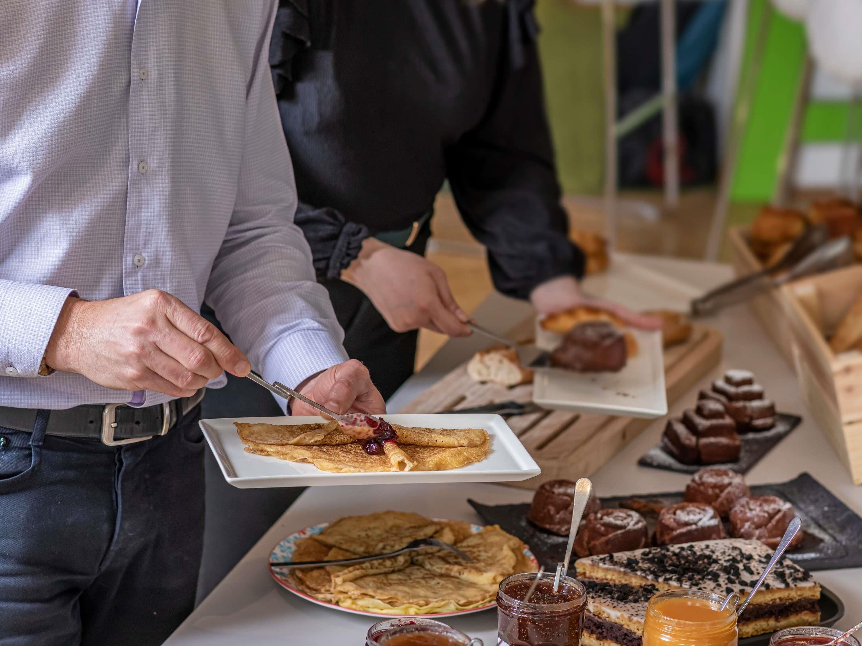 Ein Frühstücksbuffet mit verschiedenen Backwaren und Desserts.