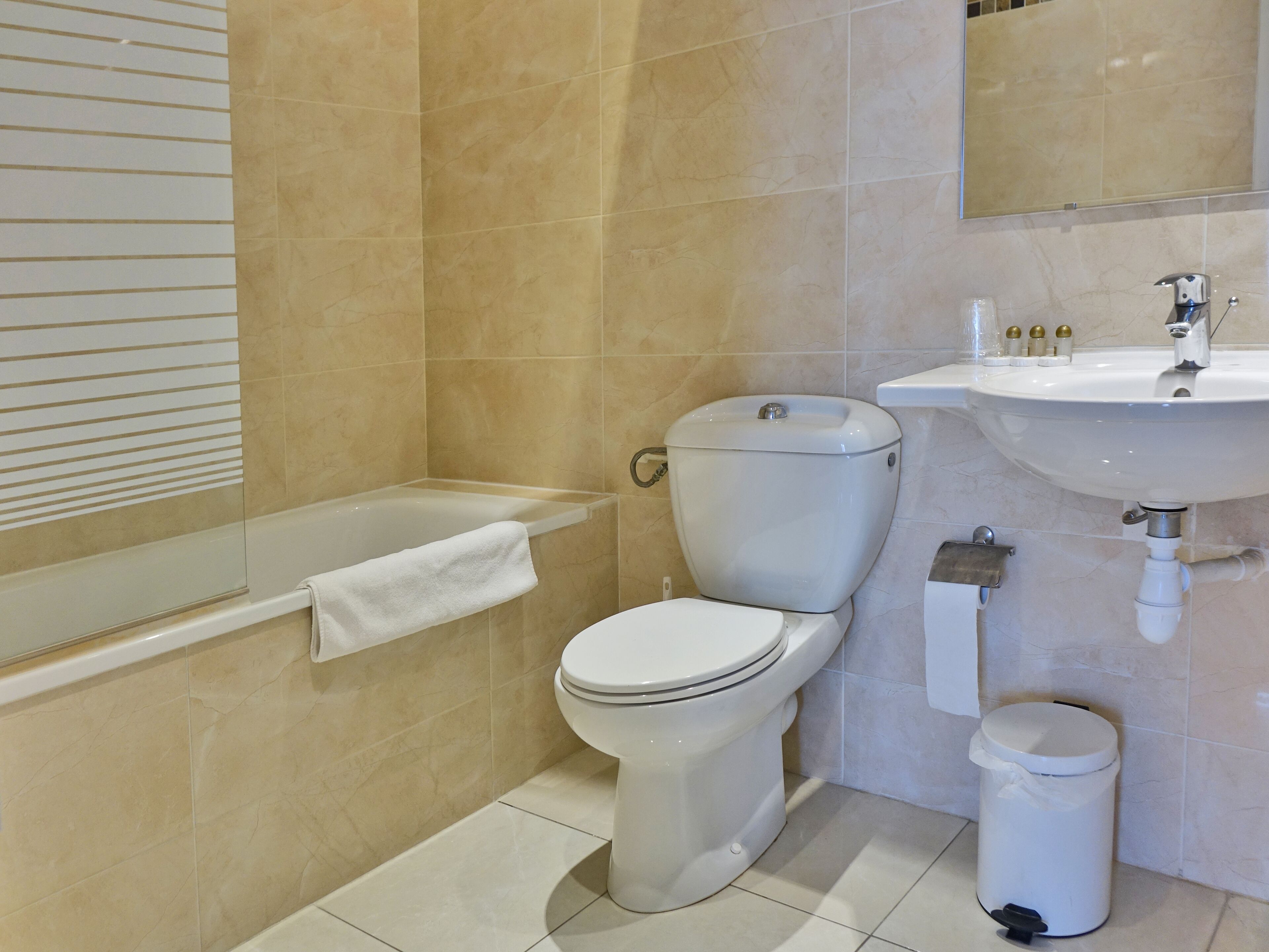 A bathroom with a toilet, sink, and bathtub.