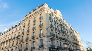 Un hotel histórico con varios pisos, balcones y detalles arquitectónicos clásicos.