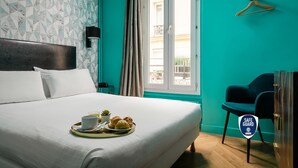 A hotel room with a bed, breakfast tray, a safe, and a view of the outside. - Hôtel Elysée Etoile (Paris)
