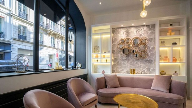 A modern interior with a sofa, two armchairs, and a small table. A large window offers a view of the street. - Hotel Royal Opera (Paris)