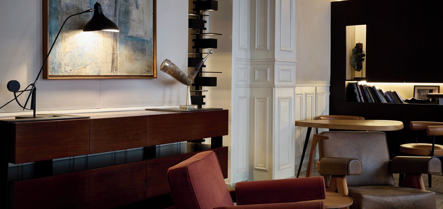 Ein modernes Interieur mit einer Holztheke, einem roten Sofa und einem runden Tisch mit Stühlen.