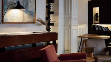 Ein modernes Interieur mit einer Holztheke, einem roten Sofa und einem runden Tisch mit Stühlen.