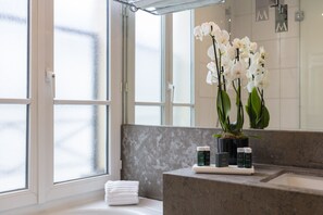 Designer toiletries, hair dryer, slippers, towels