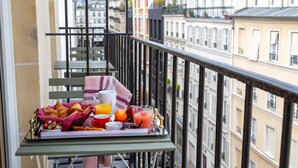 A balcony with breakfast items including croissants, orange juice, and a fruit bowl. - Hôtel Sacha (Paris)