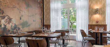 A restaurant with a large mural, checkered floor, and tables set for dining.