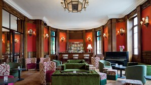 Un salón espacioso con barra, piano y asientos cómodos.