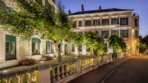 Un edificio histórico con fachada clásica, entrada destacada e iluminación exterior.