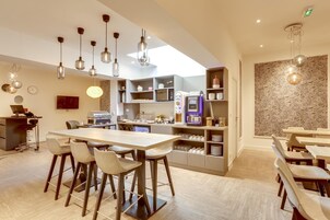Una cocina moderna con barra, electrodomésticos integrados e iluminación colgante.