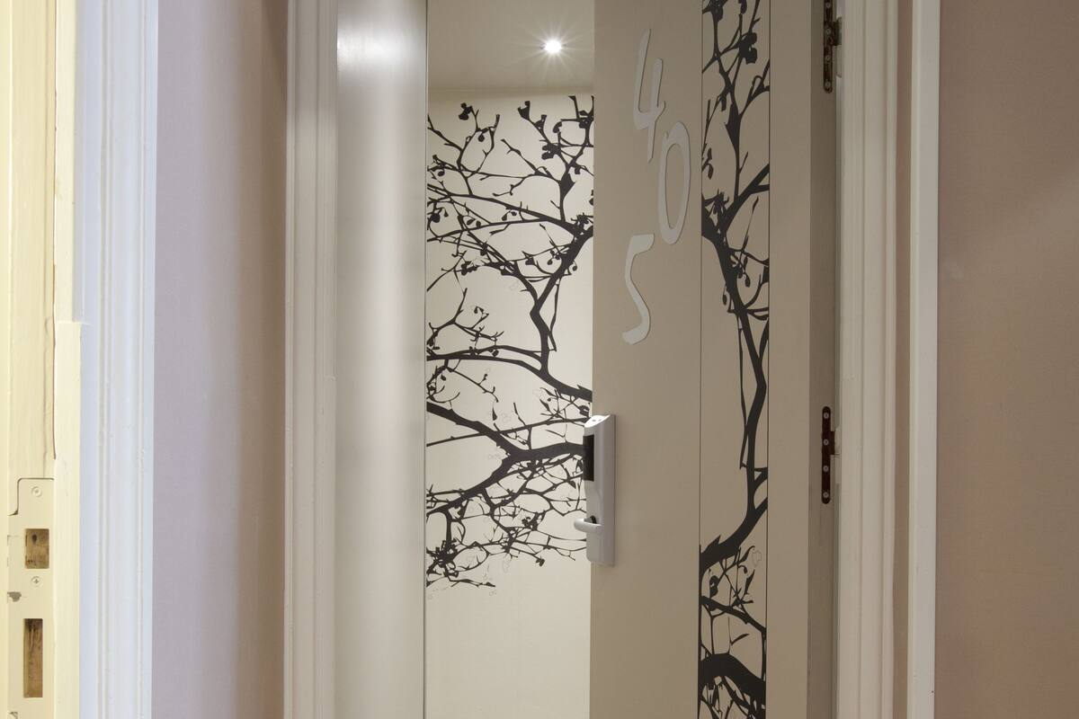 A hallway with a door featuring a tree branch design and the number 405.