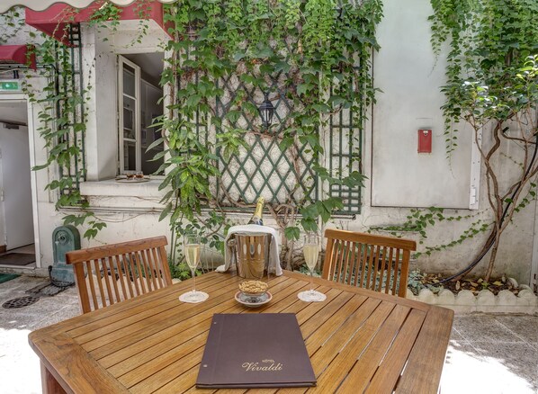 A wooden table with a menu, a bottle of champagne, and glasses of champagne.