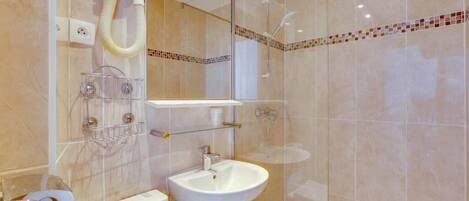 A modern bathroom with a toilet, sink, and shower.
