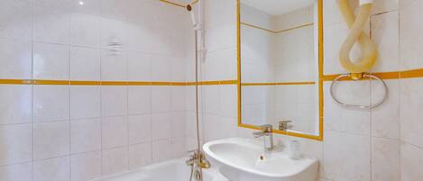 A bathroom with a bathtub, a sink, and a toilet.