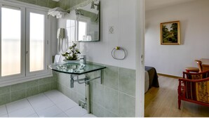 Un baño con lavamanos de cristal, espejo y ventana.