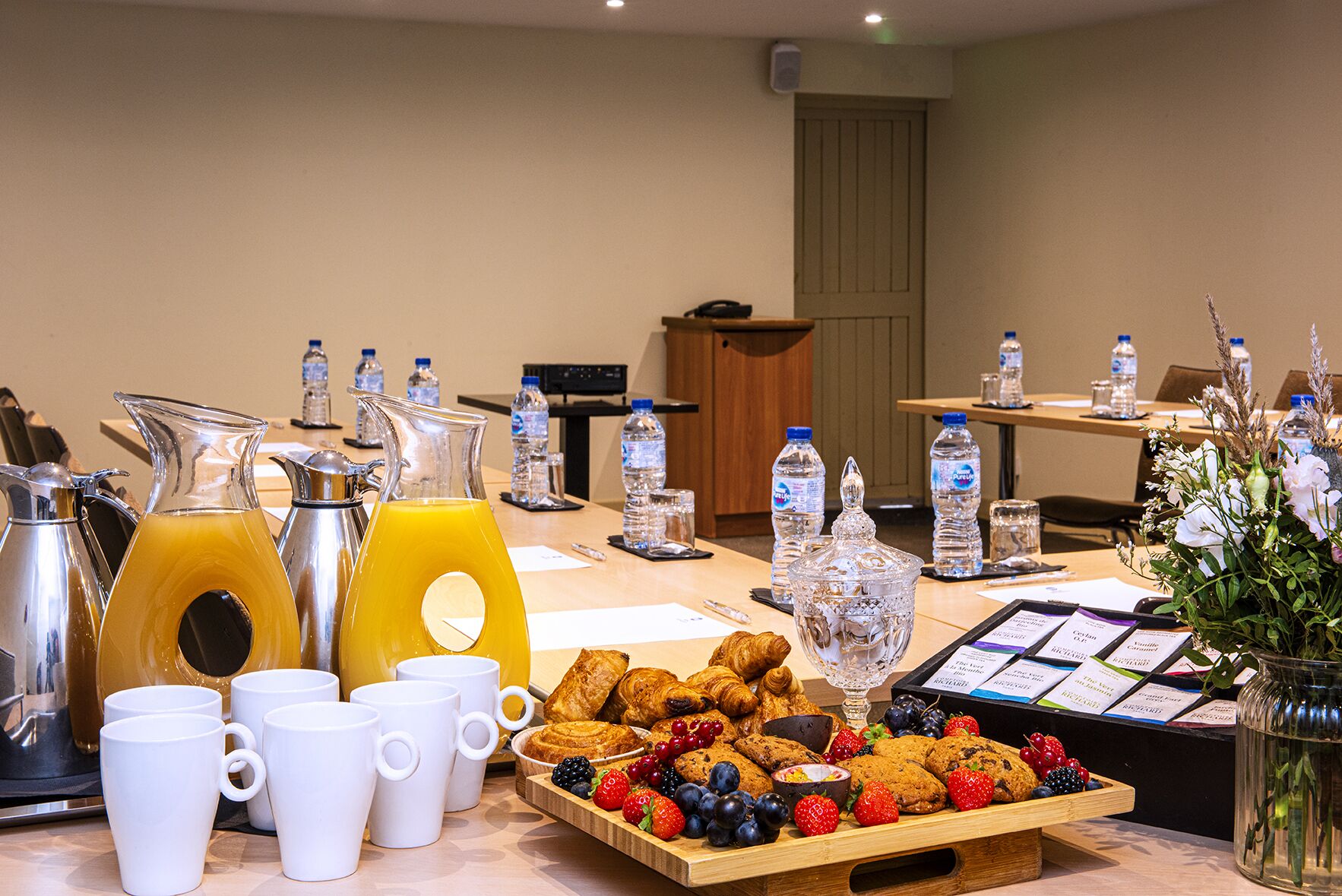 Un buffet de petit-déjeuner proposant une variété d’aliments, des bouteilles d’eau et des thermos de café.