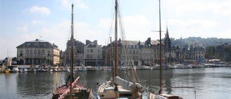 A harbor with several boats docked, a building with a dome roof, and a clear sky.