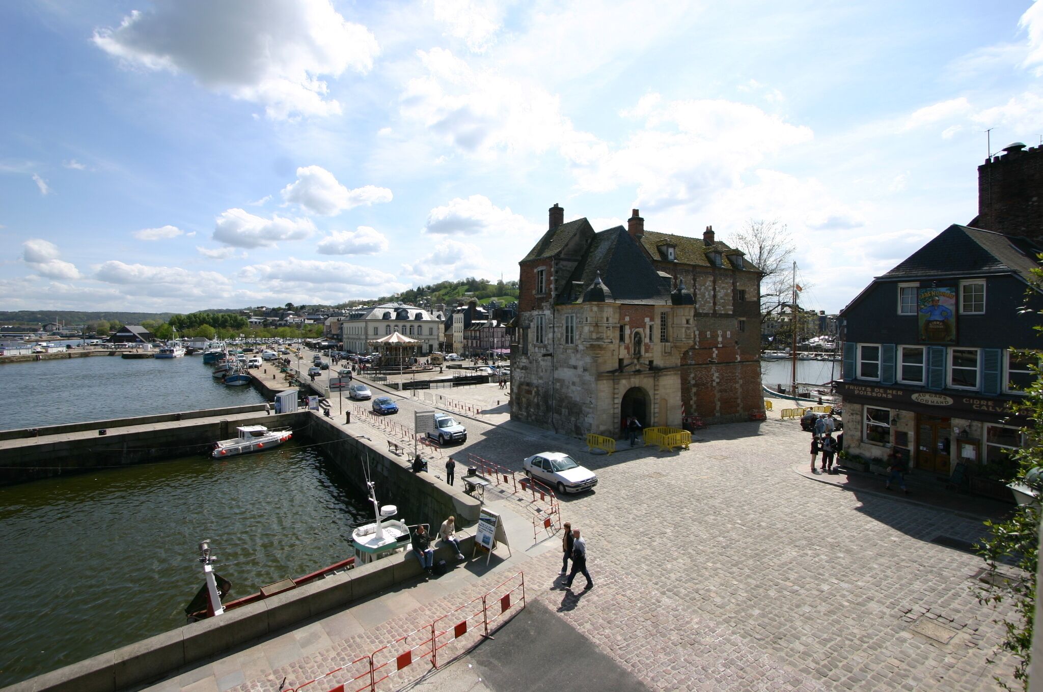 A historic stone building with a steep roof, situated by a waterfront.
