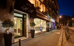 A hotel facade with a large entrance, potted plants, and a sign with a star logo. - Hôtel du Midi Paris Montparnasse (Paris)