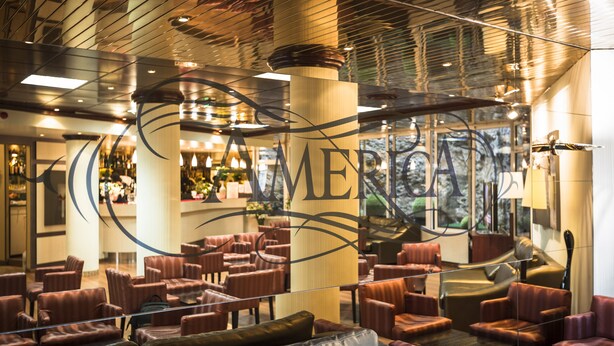 A hotel lobby with leather seating, large pillars, and a modern ceiling design. - America Hotel Lourdes (Lourdes)