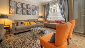 A modern living room with a sofa, armchairs, and a patterned rug.