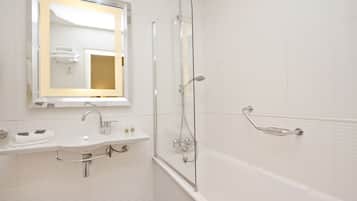 Une salle de bain moderne avec une douche à parois de verre, un lavabo avec un miroir et une baignoire.