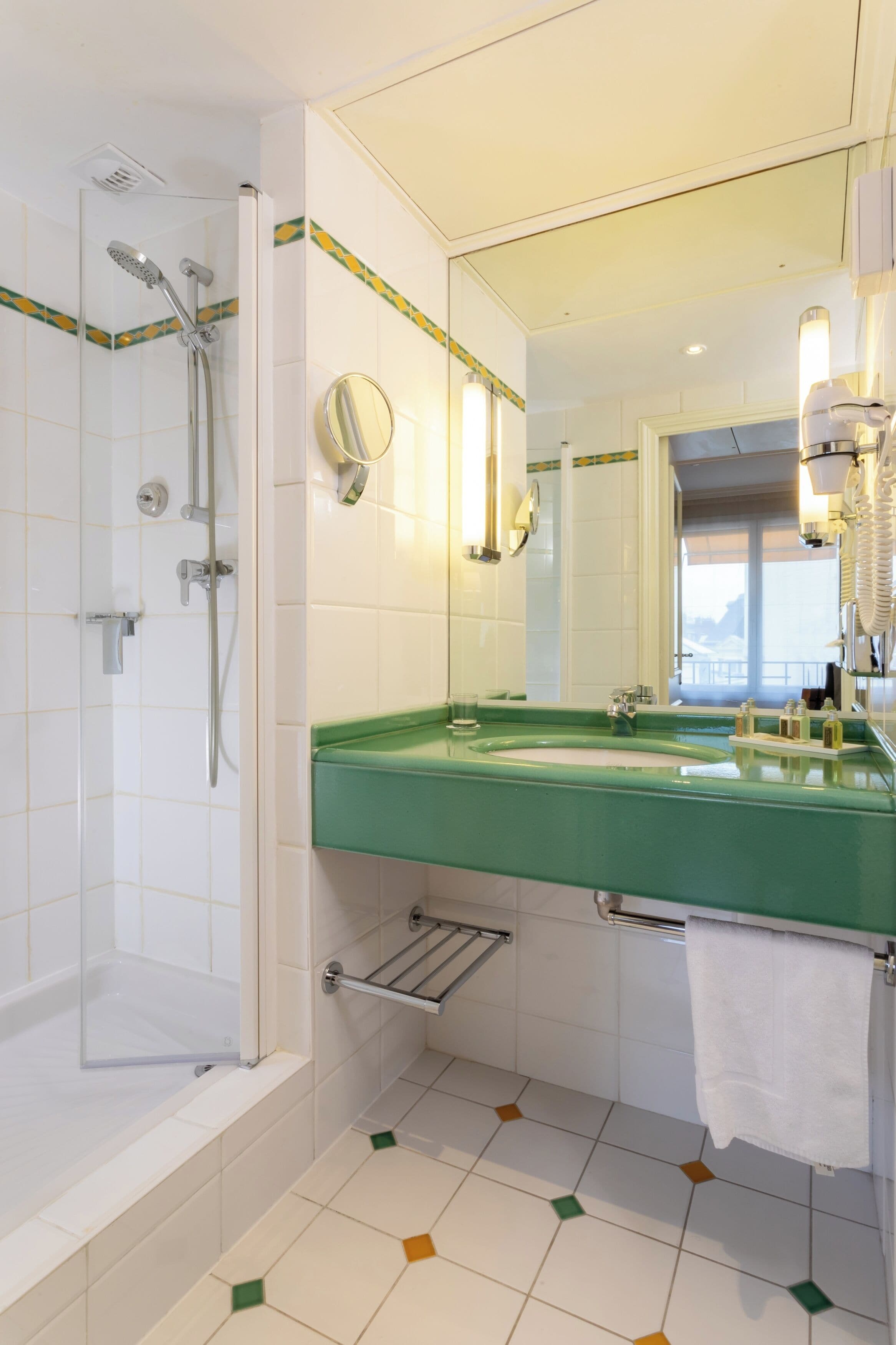 A bathroom with a bathtub, shower, green sink, and a mirror.