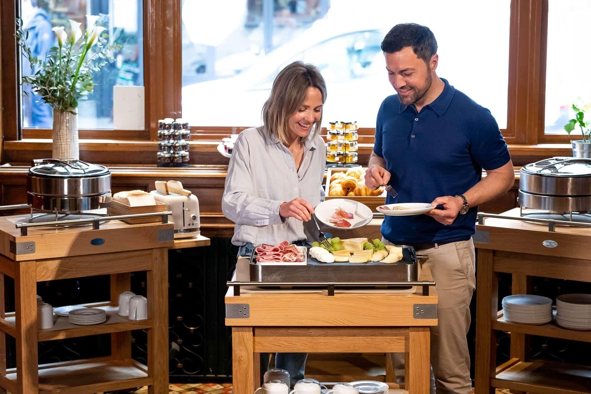Una mesa de buffet con diversos alimentos, salsas y una vista a la ventana.