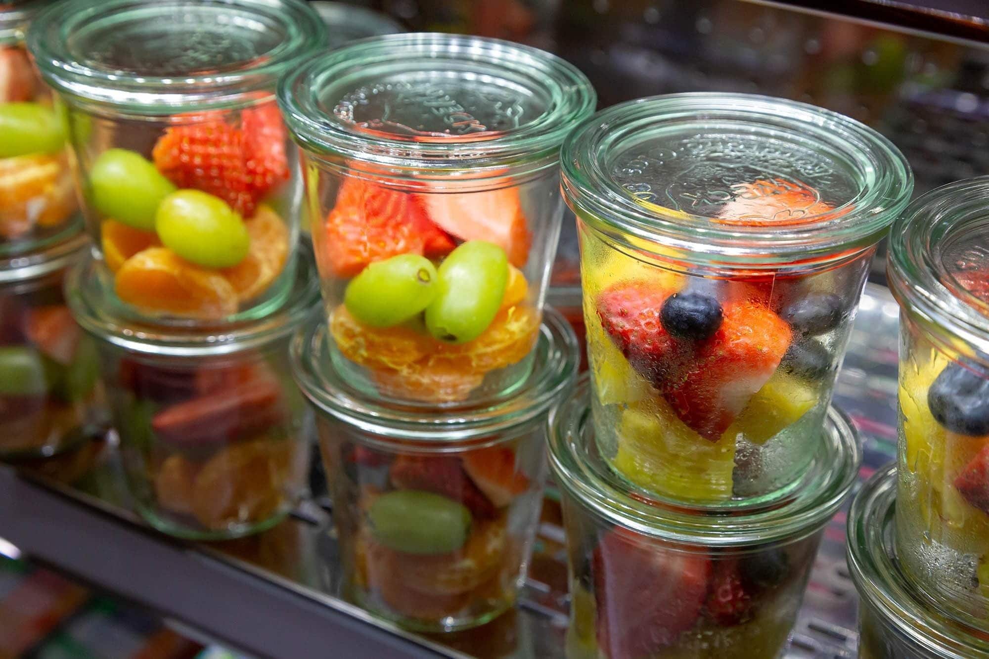 Una exhibición de frascos llenos de fruta.
