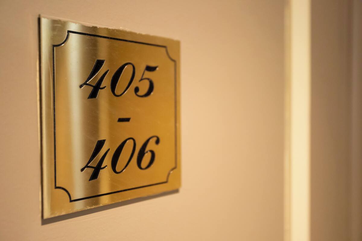 A metallic room number plaque on a wall.