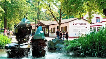 Een restaurant en hotel genaamd 'Germanyia' met terras en een waterpartij.