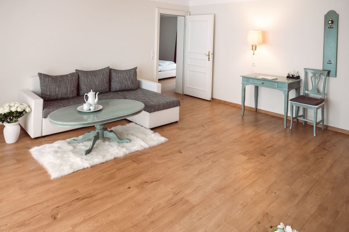 Ein modernes Wohnzimmer mit einer Couch, einem Glastisch, einem Schreibtisch und einem Sessel.